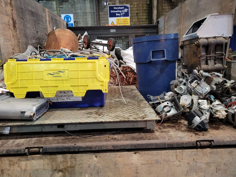 A view of a waste recycling facility with overflowing dumpsters