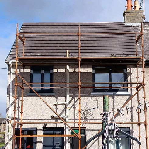 Two-story house with scaffolding covering the front