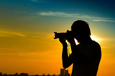 Landscape photographer in backlight during sunset