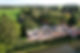 Aerial view of a construction site with partially built house in a lush rural area
