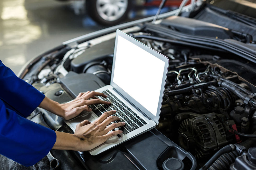 A mechanic diagnosing a car using a laptop