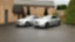 Two silver Mercedes Benz saloon cars parked in the driveway of a country house