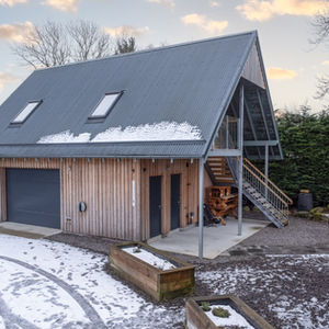 A wooden cottage surrounded by snow
