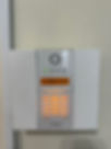 A wall-mounted security alarm keypad with an LCD screen