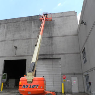 A JLG lift next to the building for cleaning and building washing