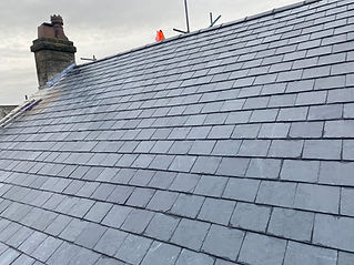 Newly installed slate roof with chimney and orange cone on top, Complete Roofing