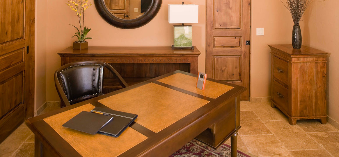 Warm-toned office with wooden furniture, tan walls, and a leather chair
