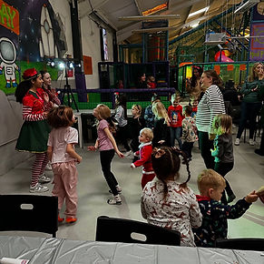 Children joyfully dancing in a colorful indoor play area