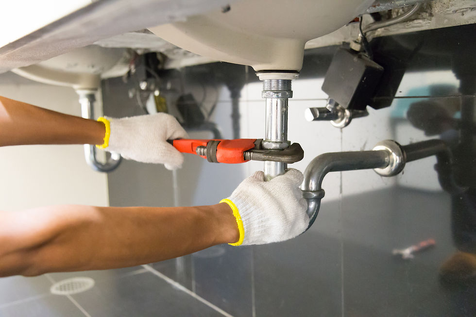 Plumber fixing sink pipe with an adjustable wrench