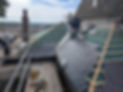 Professional installing new slate tiles on a steep roof