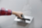 Close-up of a professional plastering a wall with a trowel