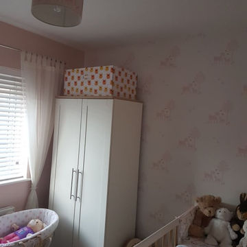 A kid's room with an almirah and wallpaper
