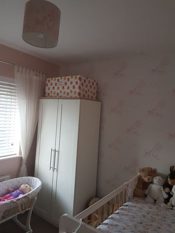 A kid's room with an almirah and wallpaper