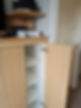 Wooden cabinet with open door revealing shelves, Xbox console on top