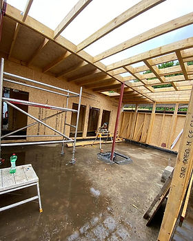 Interior of a construction site showing wooden framework, scaffolding, and unfinished walls