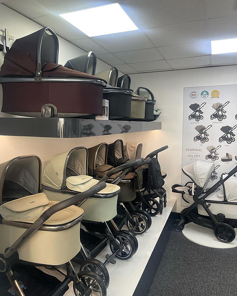 A display of luxury baby strollers in a store, showcasing various colors like beige, brown, and black