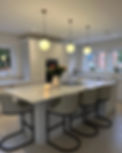 Modern kitchen with island, bar stools, and pendant lights