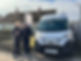 Two men stand beside a white van parked in front of a residential property