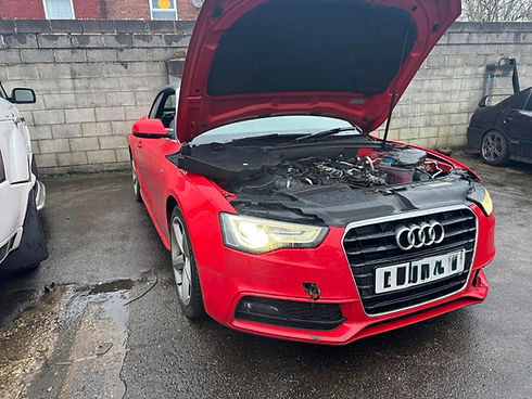 A red Audi with its hood open, revealing the engine
