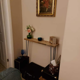 A corner with a framed painting, a wooden shelf with decor
