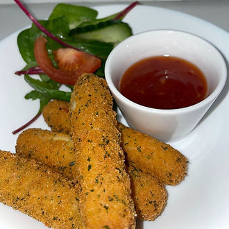 A plate with mozzarella dippers and tomato, and a small bowl of dipping sauce