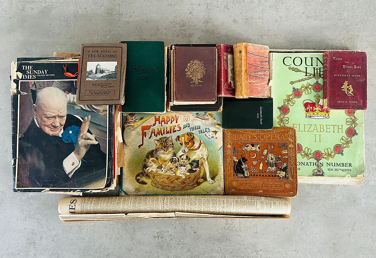 A collection of antique leather-bound books, vintage childrens annuals including Babys Opera by Walter Crane, and historical mid-century magazines featuring Winston Churchill and Queen Elizabeth II coronation editions. 