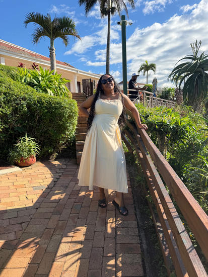 A woman posing in a lush green garden