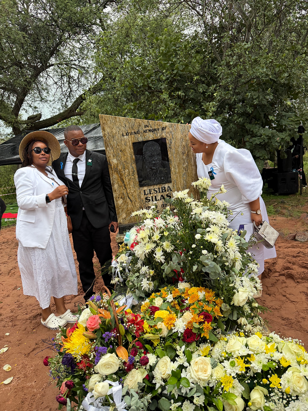 Three people standing by the grave site