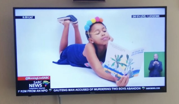 A television screenshot of a girl holding a book