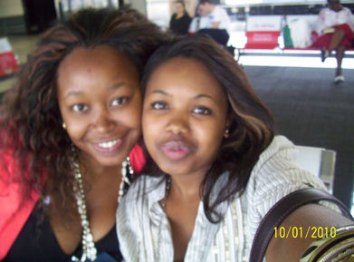 Two women posing head to head, one with a smile and the other with a pout