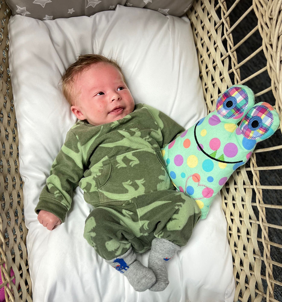 Thumbnail: Smiling baby with the Friendly Monster Weighted Plush