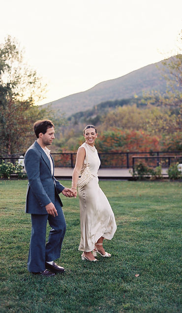 Bride and groom frolicking on alpaca farm before rehearsal dinner