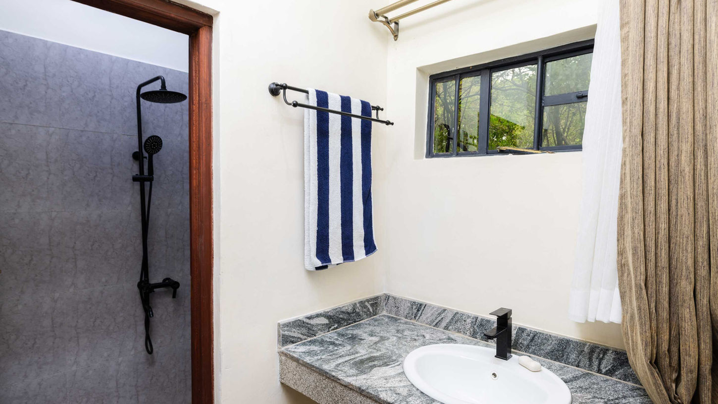 Modern bathroom with window sink to right and shower