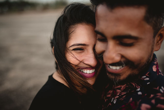 Couple sharing a close, affectionate moment outdoors, smiling and leaning into each other, representing emotional connection, intimacy, and secure attachment in relationships.