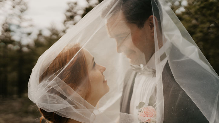 Häävideokuvaus auringonlaskussa – morsiuspari hunnun alla intiimissä hetkessä.