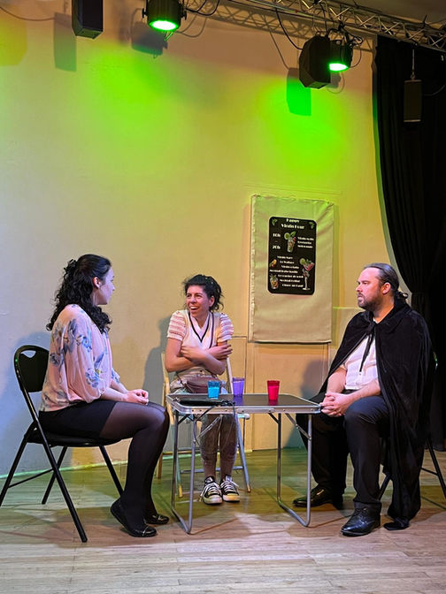 Liens enchantés, pièce d'Opélie Gass et Angélique Russo, jouée en mai 2025 au Théâtre du Temps (Paris 11ème). 
3 personnages en train de discuter à une table.