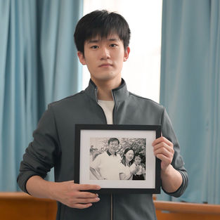Nathan Yin, student dancer touring with Shen Yun, holds a picture of his parents persecuted by the Chinese Communist Party for their belief in Falun Gong.