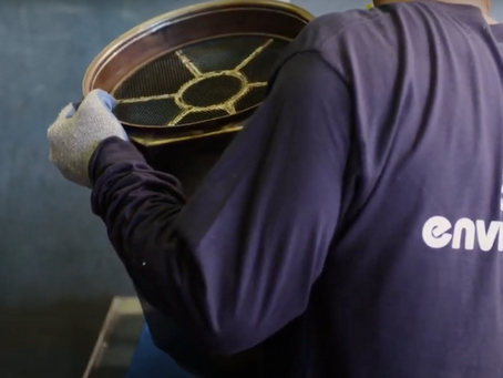 an Enviromotive employee carrying a dirty DPF