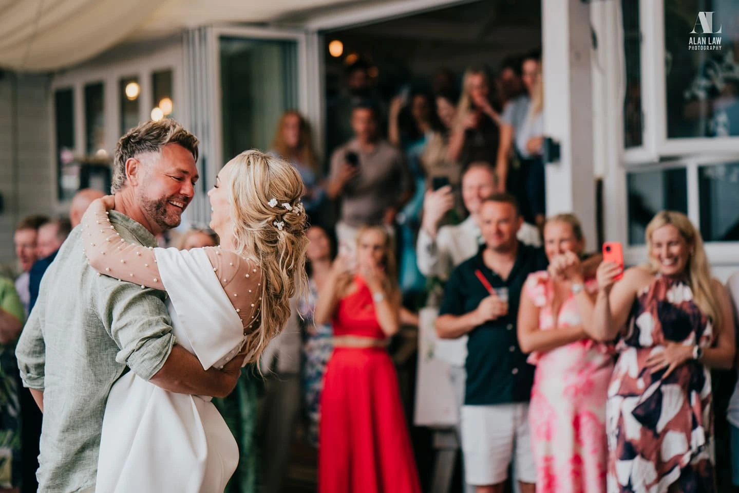 Brian and Dani McFadden with friends celebrating on Lusty Glaze beach at their wedding, Cornwall.