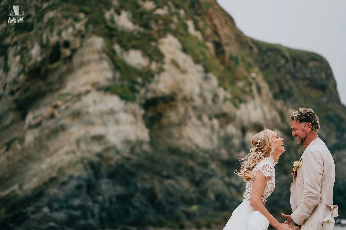 Brian and Dani McFadden holding hands and looking at each other on Lusty Glaze beach during their wedding, Cornwall.