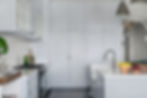 Classic kitchen design by Porch Light Interiors in Brisbane featuring marble countertops, pendant lighting, custom blue cabinetry and silver fixtures.