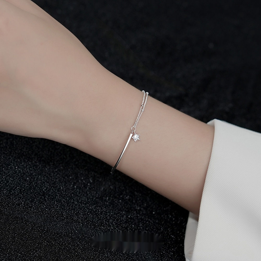 XINGX sterling silver bracelet on a woman's wrist