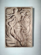 a wood carving of a woman with long hair