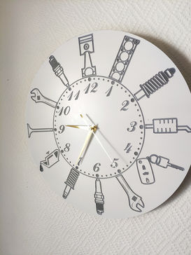 a clock with drawings of engine parts around it