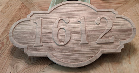 a wooden sign with the number 1612 carved into it