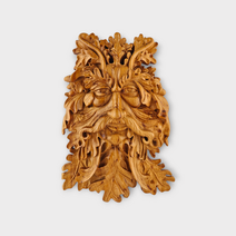 Birch wood carving of Green Man face formed from leaves forest spirit wall art
