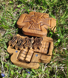 a wooden box with a cross carved into it sits in the grass