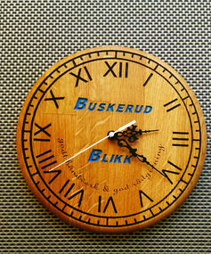 a wooden clock with the name buskerud on it