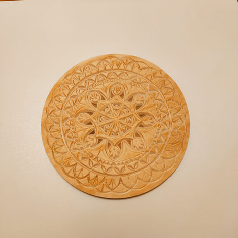 a wooden plate with a circular design on it