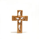 a wooden cross with two hearts carved into it